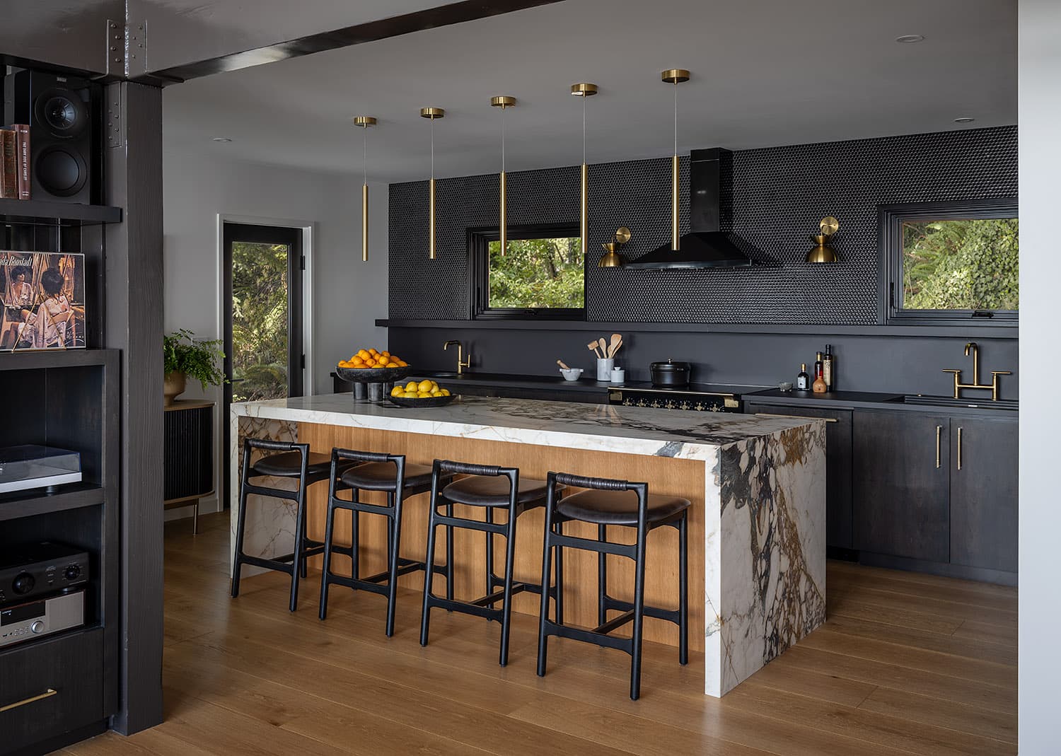 Des Moines remodel — marble island kitchen with brass pendants and dark cabinetry